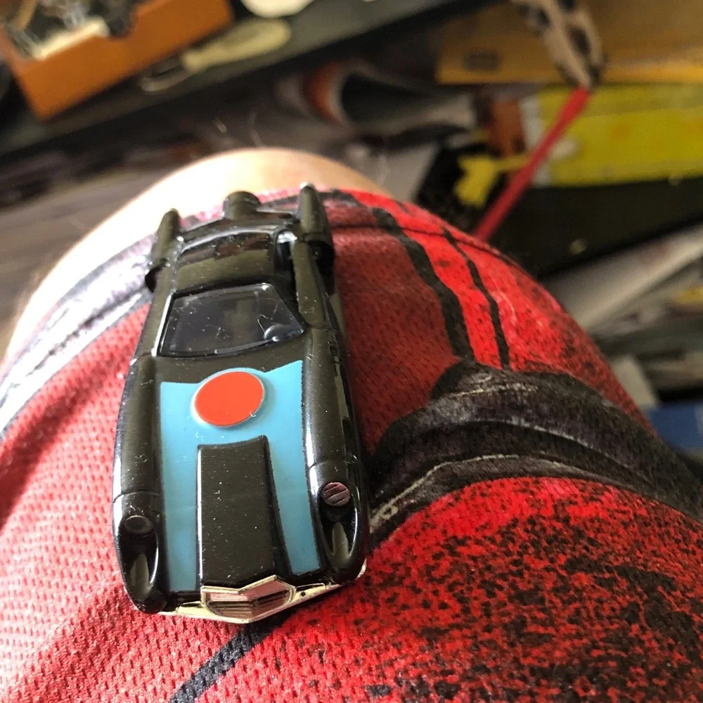 Black Toy Sports Car with Blue Hood and Red Dot